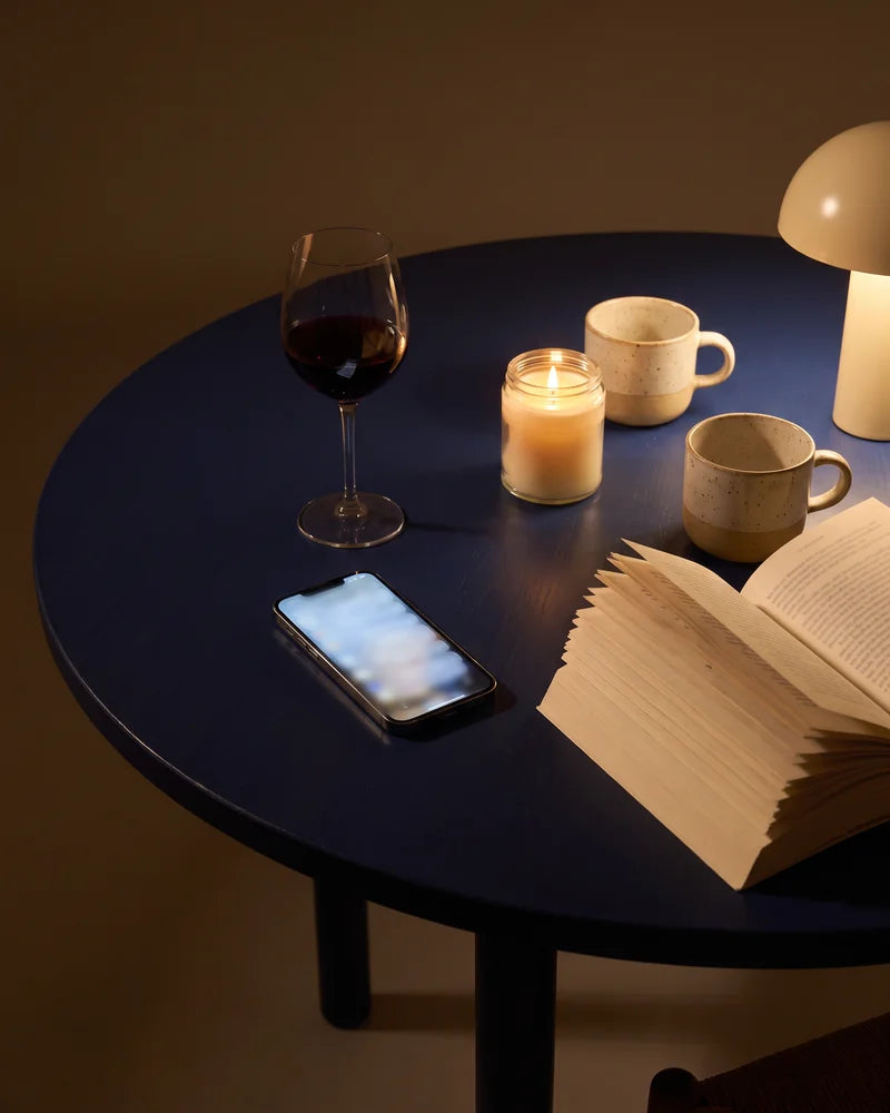 Detail: a candle, a glass of wine and the book nearly finished. AI-generated image.