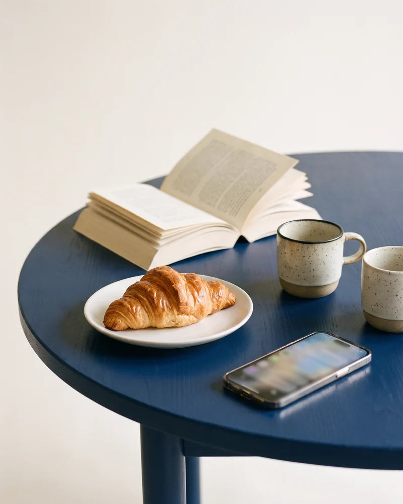 Detail: the untouched croissant and a phone full of messages. AI-generated image.