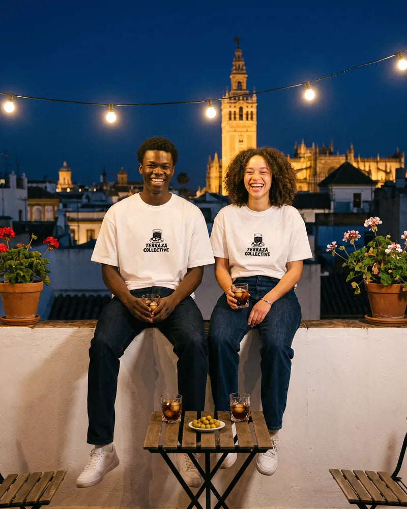 Two friends wearing the Terraza Collective relaxed and cropped T-shirts on a rooftop in Seville at night, front view. AI-generated image.