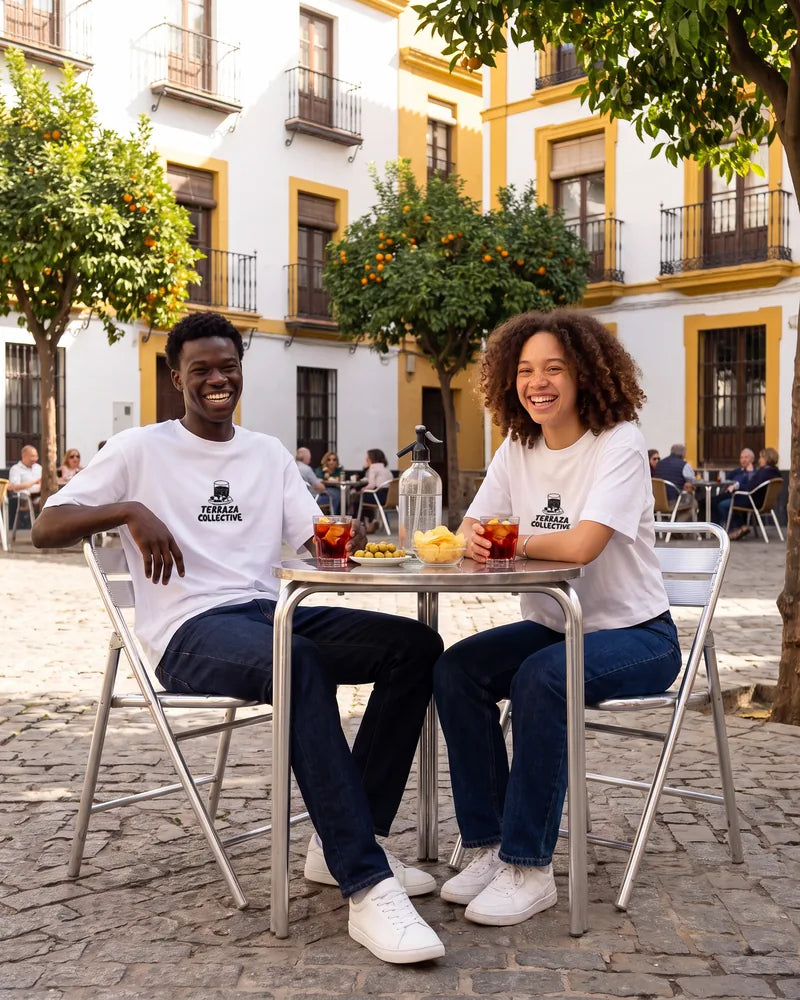 Two friends wearing the Terraza Collective relaxed and cropped T-shirts at a terrace in Seville, front view. AI-generated image.