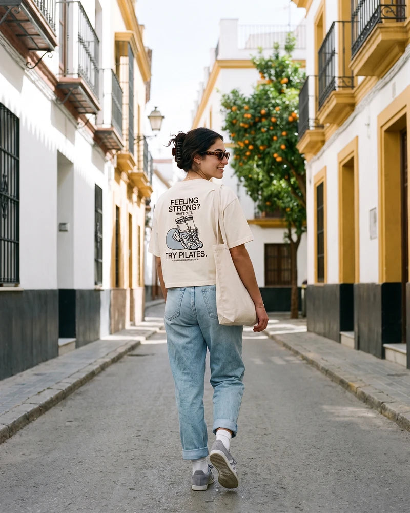 Try Pilates digital campaign: cropped T-shirt, back view, in the street scene. Image created or edited with AI.